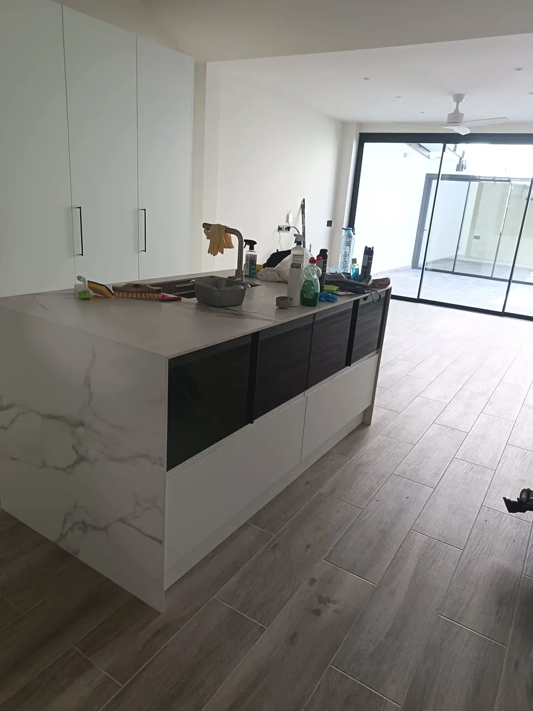Cocina con isla y encimera de porcelánico tras la limpieza fin de obra en Sabadell