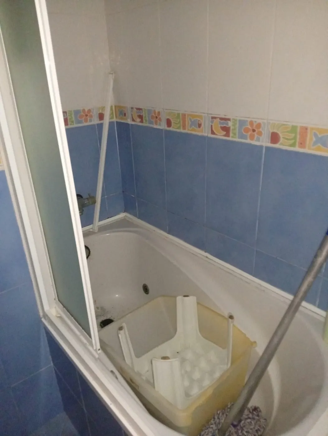 Bañera con moho en el desagüe y silicona ennegrecida antes de la limpieza