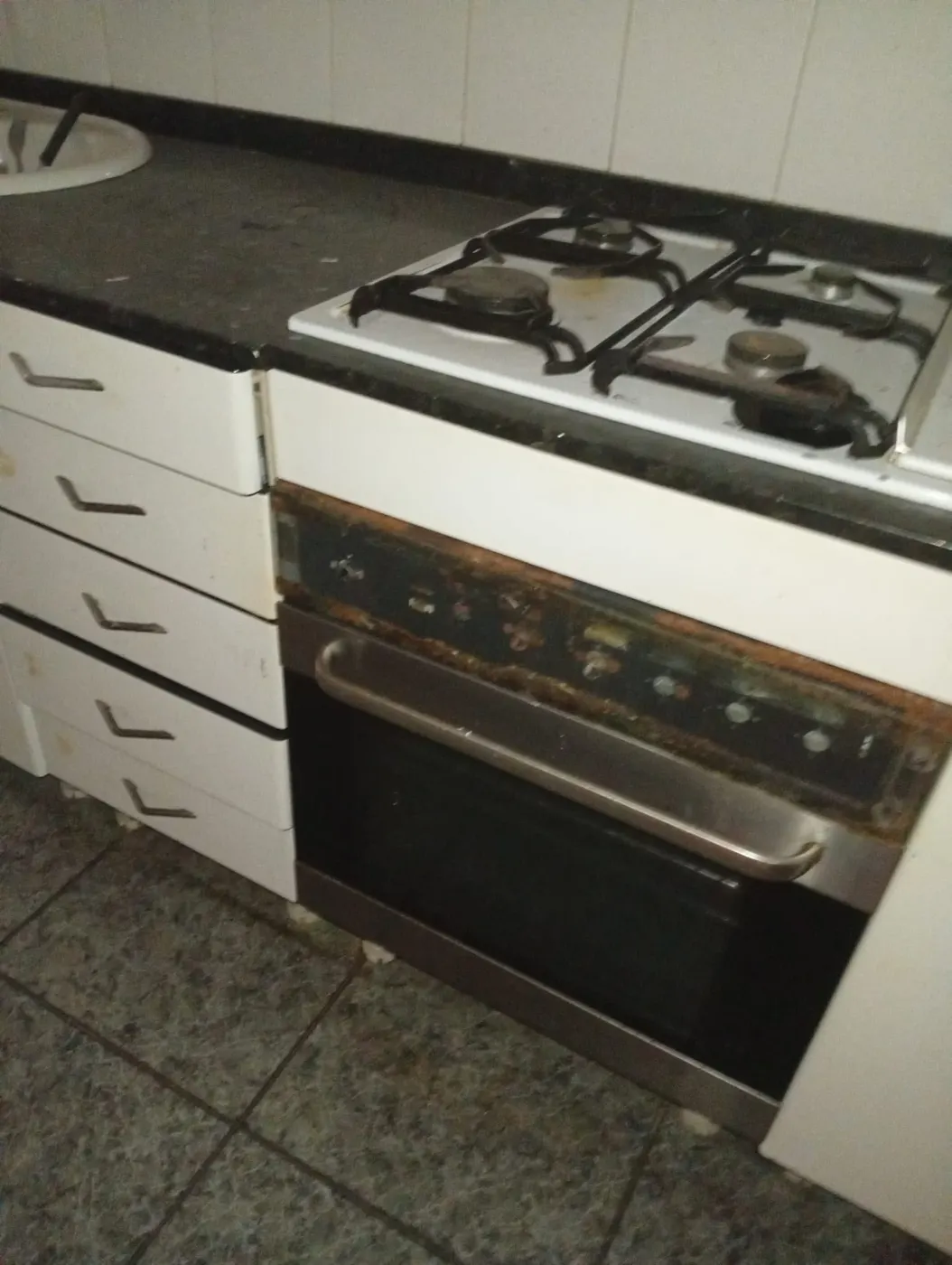 Horno con grasa carbonizada y óxido antes de la limpieza profunda de la cocina