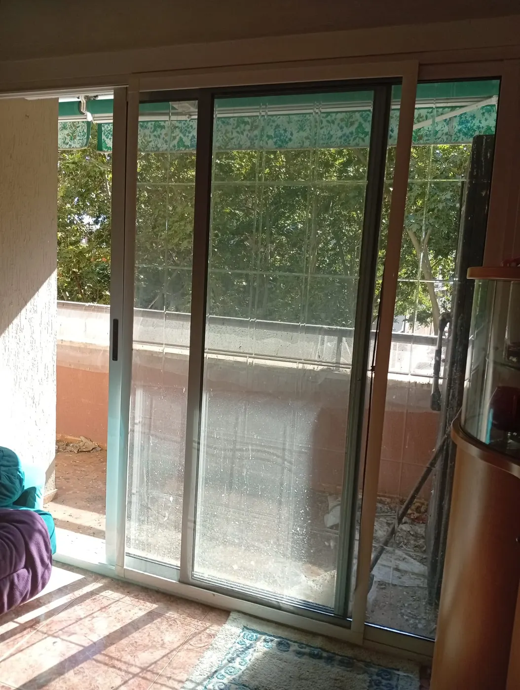Cristalera de balcón opaca por la suciedad acumulada antes de la limpieza