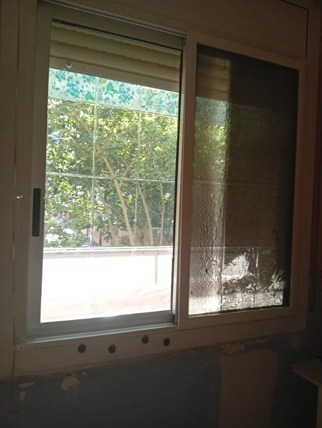 Ventana con restos de cemento y pintura secos antes de la limpieza